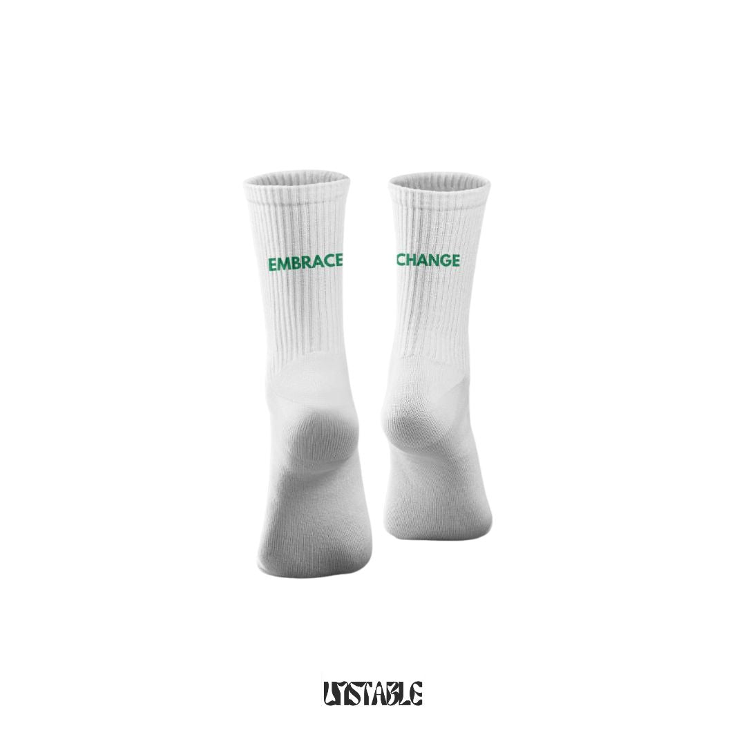 White socks with green text 'Embrace Change' design on a white background