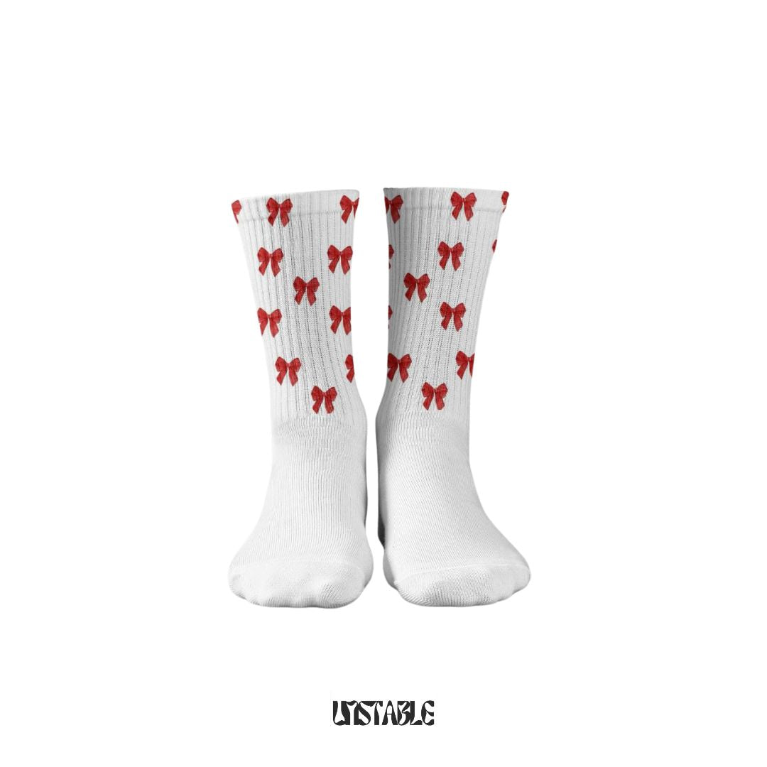 A pair of white socks with red heart patterns displayed against a plain background, with the brand name 'UNTABLE' visible in the image.